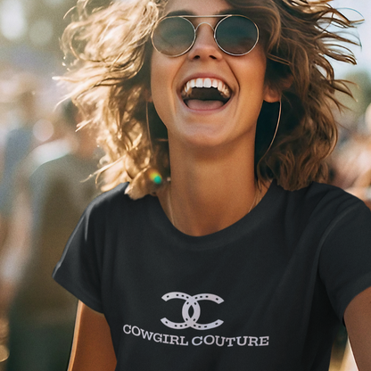 Woman smiling in sunglasses wearing a Cowgirl Couture t-shirt at an outdoor festival.