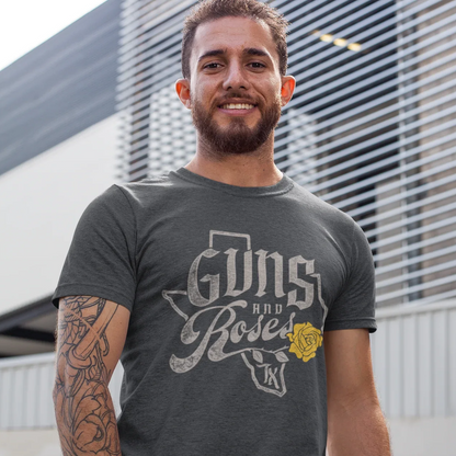 Man wearing a Guns and Roses Texas t-shirt standing outside with a tattooed arm and smiling.